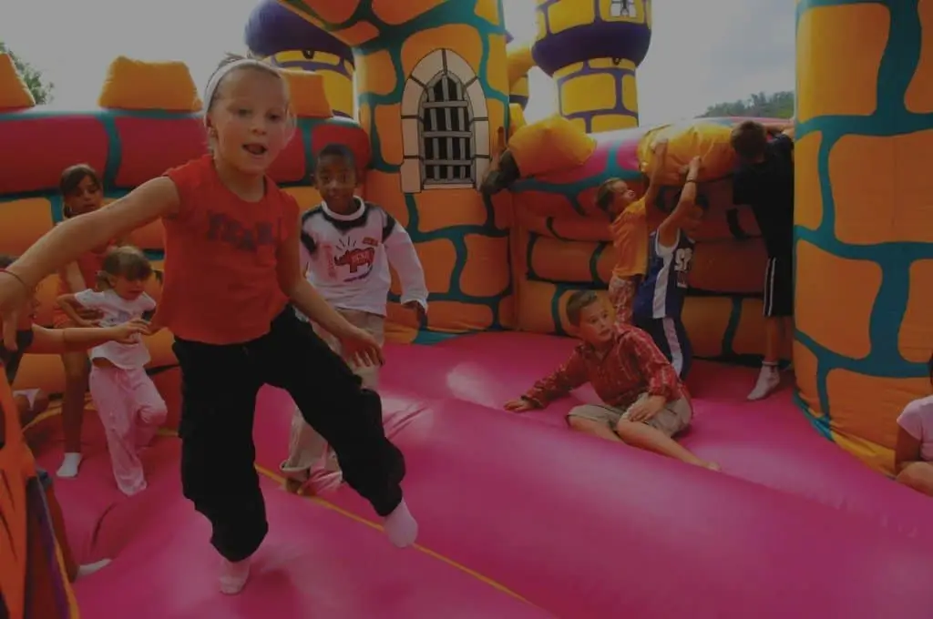 Children playing inside an inflatable bounce house during a party event